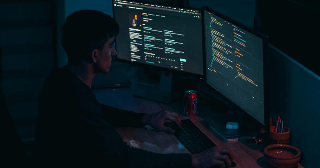 A software engineer reviewing AI-generated code on multiple monitors, illustrating how AI coding tools make code cheap, not judgment